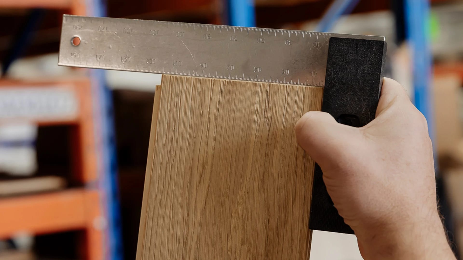 Measuring width of flooring plank for consistency.